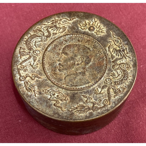 1192 - A circular bronze scroll weight with dragon detail to top rim.  Approx. 3cm tall x 7.5cm diameter.