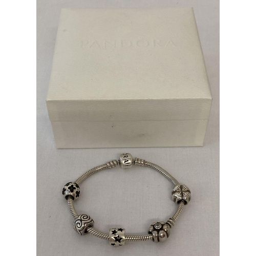 1012 - A silver Pandora charm bracelet with 5 charms. Charms include four leaf clover, clear stone set, flo... 