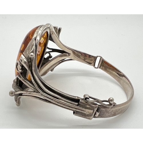 1001 - A large Art Nouveau style silver bracelet with decorative Lily design mount, set with a large oval a... 