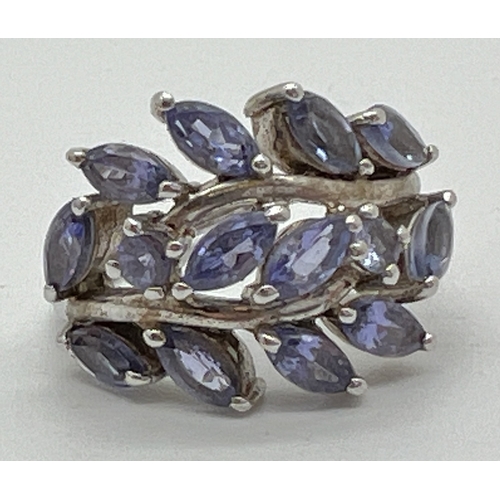 1014 - A silver floral design Tanzanite set dress ring. Top of ring set with 12 marquise cut and 2 round cu... 