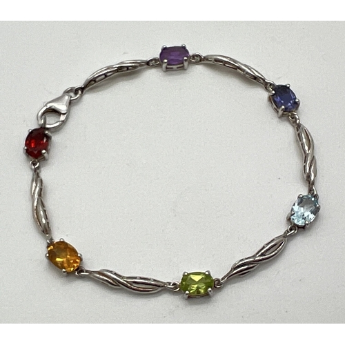 1017 - A silver and gemstone set bracelet with lobster claw clasp. Alternating twist design links and oval ... 
