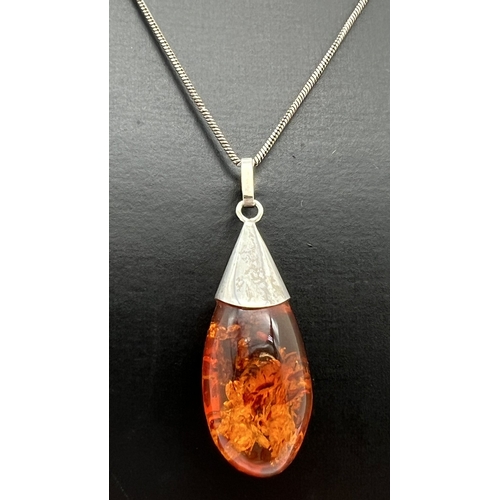 1019 - A teardrop shaped amber pendant with white metal cap and fixings, on a 22
