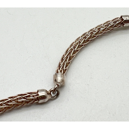 1025 - A silver Wheatsheaf chain bracelet. 4 semi circular chain links with capped ends and a lobster style... 