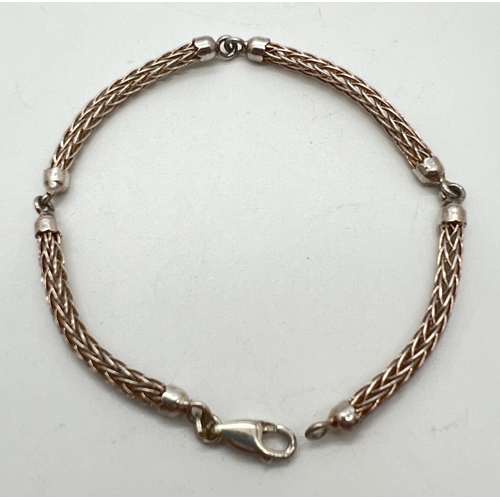 1025 - A silver Wheatsheaf chain bracelet. 4 semi circular chain links with capped ends and a lobster style... 