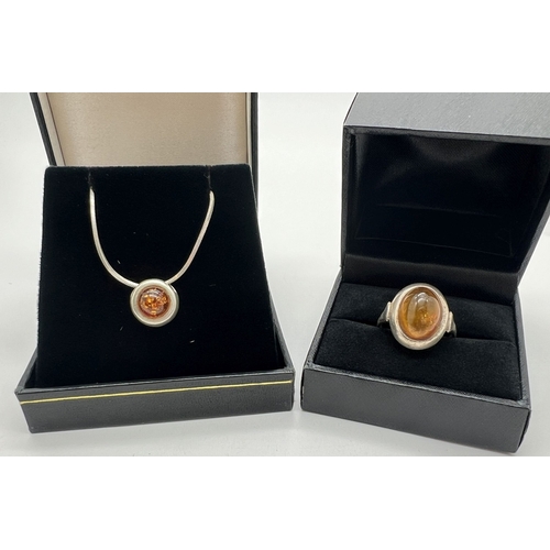 1026 - A small circular silver & amber sliding pendant necklace and matching ring. Pendant set with a caboc... 
