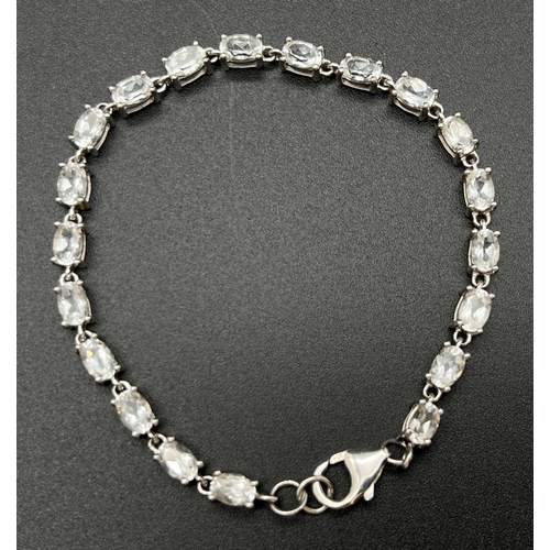 1031 - A decorative 8 inch silver bracelet set with 20 oval cut white topaz stones. Silver marks to lobster... 