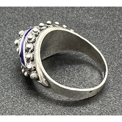 1035 - A silver ethnic design cathedral style dress ring with blue enamel detail. Central bead decoration s... 
