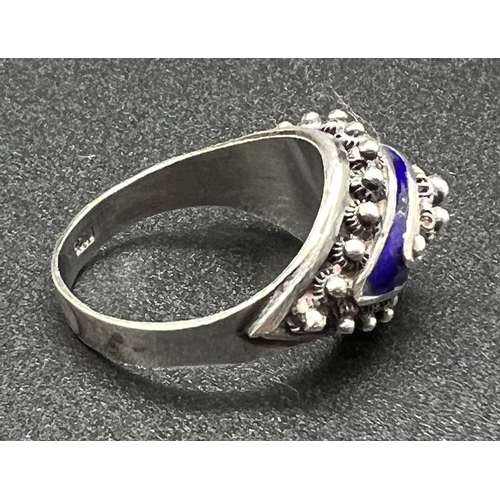 1035 - A silver ethnic design cathedral style dress ring with blue enamel detail. Central bead decoration s... 