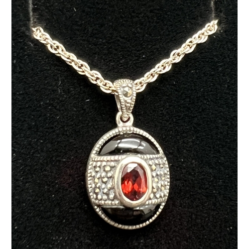 1005 - A silver pendant necklace and matching stud earrings each set with black onyx, garnets and marcasite... 