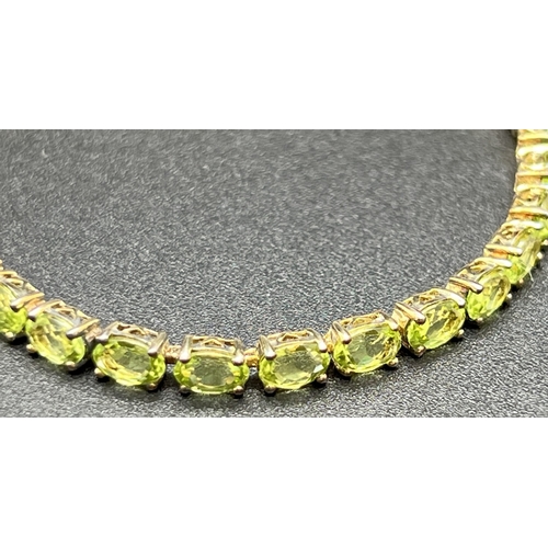 1050 - A modern design silver gilt bracelet set with 30 oval cut peridot stones. Push clasp with double saf... 