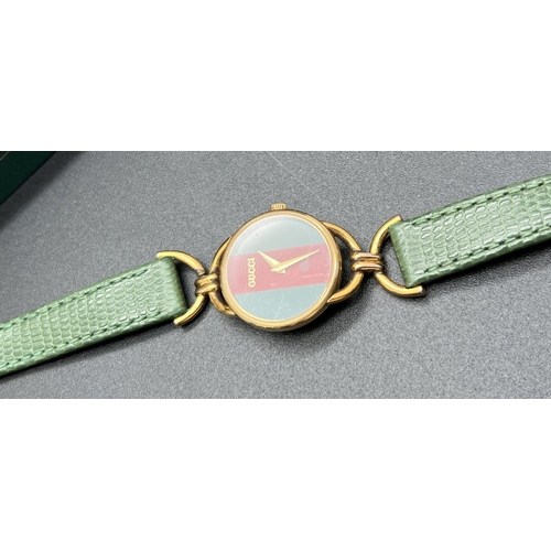 1168 - A vintage horse bit wristwatch by Gucci, 6000L. Classic green and red stripe detail to face with gol... 