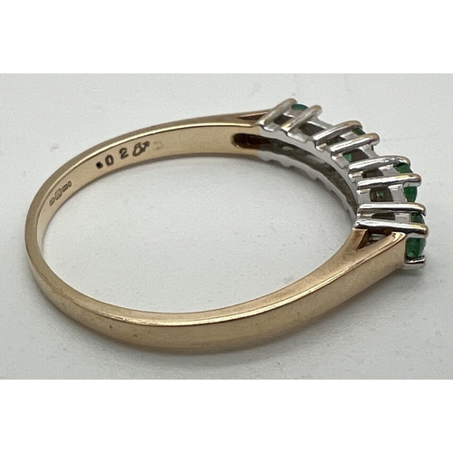 1003 - A 9ct gold, emerald and diamond half eternity ring. Alternating small round cut emeralds and illusio... 