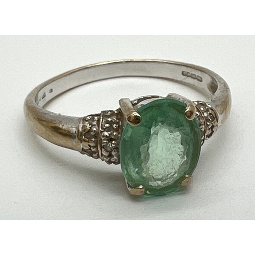 1061 - An 18ct gold green amethyst and diamond ring with central oval cut green amethyst and 2 rows of smal... 