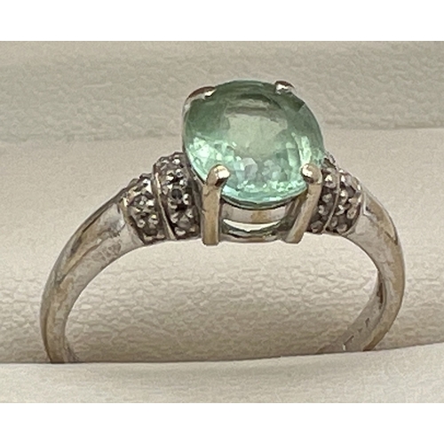 1061 - An 18ct gold green amethyst and diamond ring with central oval cut green amethyst and 2 rows of smal... 