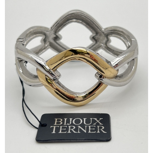 1068 - A costume jewellery twist link design bangle in silver and gold tones by Bijoux Terner, new with tag... 