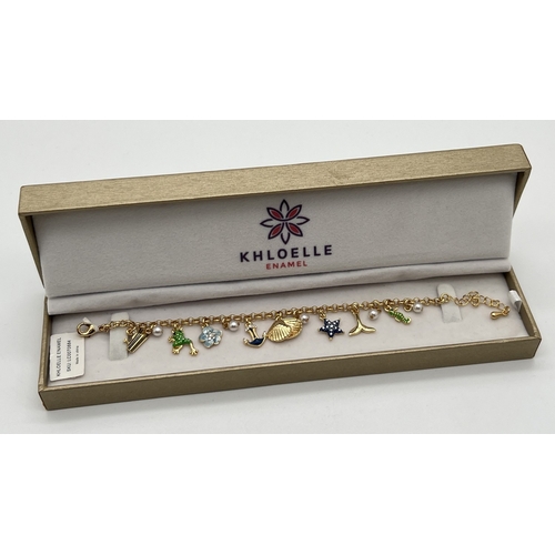 1071 - A boxed gold tone and enamel aquatic themed charm bracelet by Khoelle, new with tags. Charms include... 