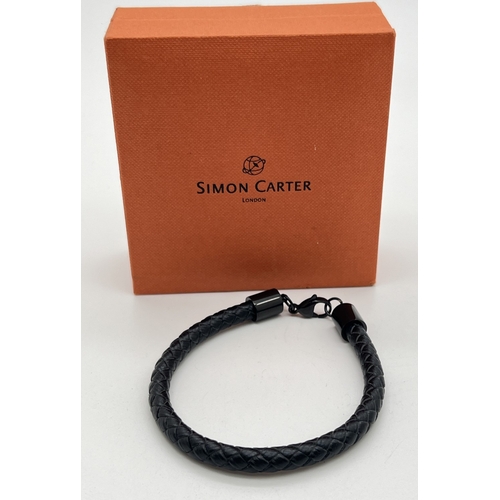 1072 - A men's boxed black leather plaited bracelet with black metal hardware and lobster claw clasp by Sim... 