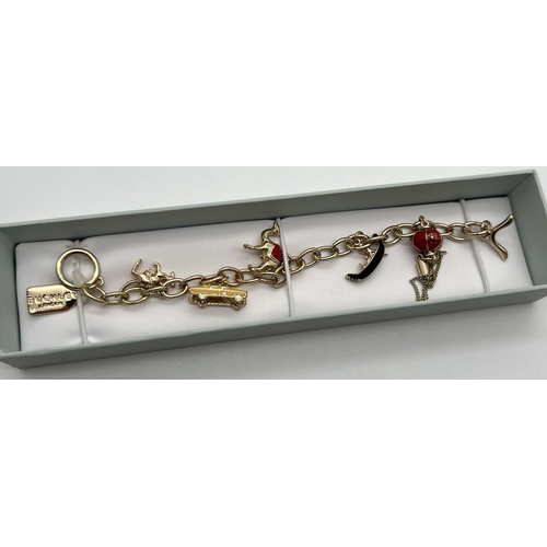 1075 - A costume jewellery charm bracelet by Buckley London, with enamel decorated charms, nameplate and T ... 