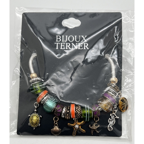 1076 - A costume jewellery charm bracelet with multiple charms by Bijoux Terner, new & in original packagin... 