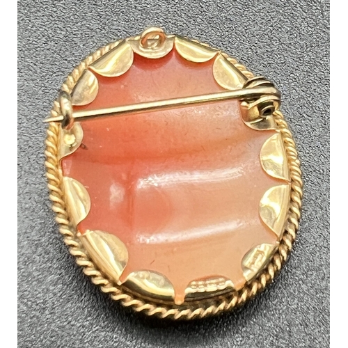 1085 - A 9ct gold oval shaped cameo brooch with twist design mount. With hanging bale and hooked clasp for ... 