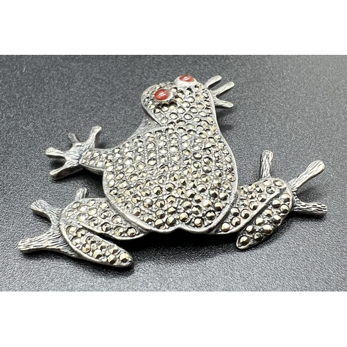 1087 - A large 925 silver brooch modelled as a frog, set with marcasite stones and 2 cabochons of carnelian... 