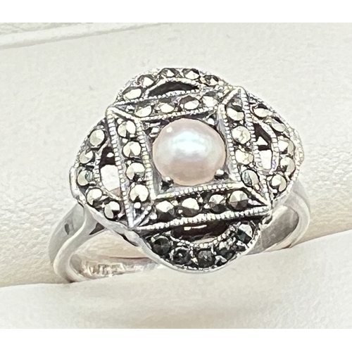 1088 - A large Art Deco design silver dress ring set with marcasite stones and central pearl. Stamped silve... 