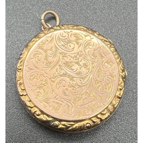 1092 - A large antique 9ct rose gold circular shaped locket, heavily engraved with scroll and foliate desig... 