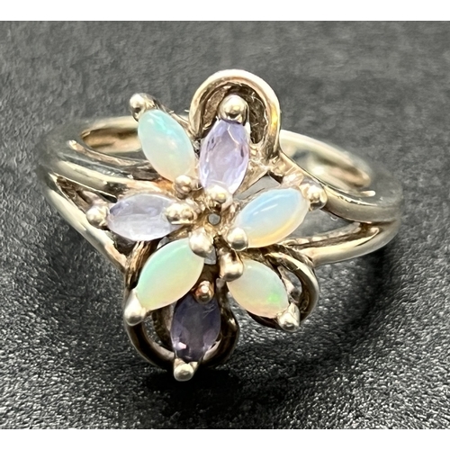 1163 - An unmarked white metal dress ring of floral design, set with marquis cut opals & tanzanite stones. ... 