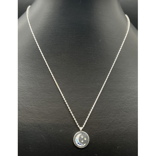 1164 - An Estella Bartlett Moon & Stars pendant necklace set with blue & clear coloured gemstones. 16