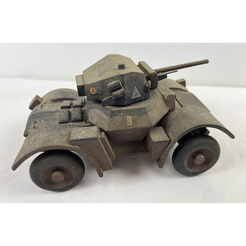 A wooden scratch built WWII armoured car, possibly Daimler, with hand painted decals to include Royal Armoured Corp, armoured car white triangle and XII Corps. Vendor advises item was built by servicemen serving in XII Corps Normandy, Operation Market Garden, using pieces of wood available. Some small areas of age related damage. Approx. 14 x 26cm.