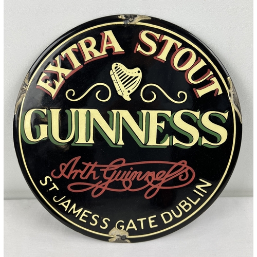 1203 - A small circular enamelled metal wall advertising sign for Guiness. Approx. 30cm diameter.