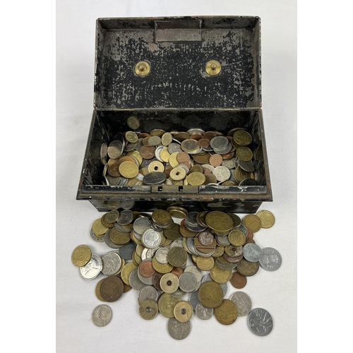 29 - A vintage black cash tin containing a collection of vintage foreign coins and tokens. To include exa... 