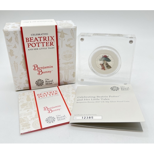 A boxed Royal Mint 2017 silver proof Beatrix Potter Benjamin Bunny 50p coin with colour detail to reverse. In protection capsule and perspex presentation block. No. 12385, complete with CoA and information card.