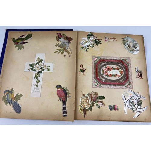 231 - A late Victorian scrap album containing greetings cards, silks and scraps. Album has navy blue cover... 