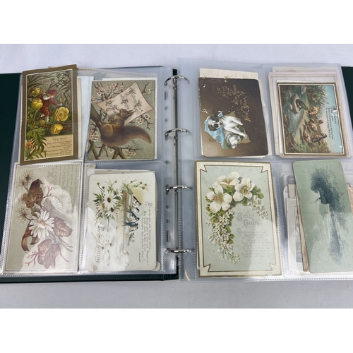 253 - An album containing 165 assorted Victorian & Edwardian greetings cards displayed in clear plastic en... 