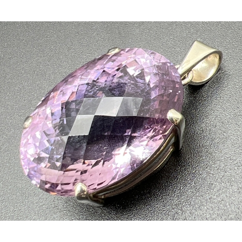 1054A - A large silver modern design pendant set with a  checkerboard cut oval amethyst. Silver mark to insi... 