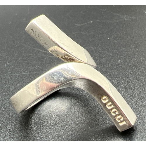 1060 - A 925 silver modern twist design dress ring by Gucci. Silver marks throughout and Gucci name to ride... 