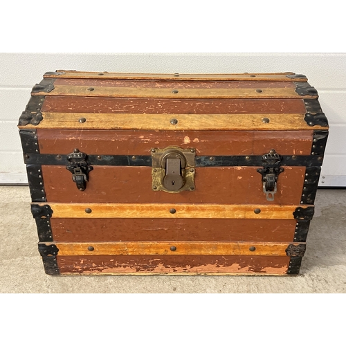 An antique 2 handled dome topped trunk with wooden banding, studded detail and original brass lock. Approx. 50cm tall x 68cm long.