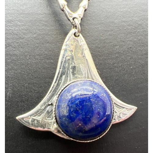 1061 - A large silver pendant modelled as a flying beetle with suspended lapis cabochon, on an 18