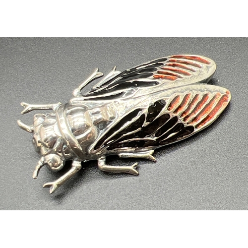 1062 - A large silver brooch modelled as a winged insect, with coloured enamelled detail to wings. Stamped ... 