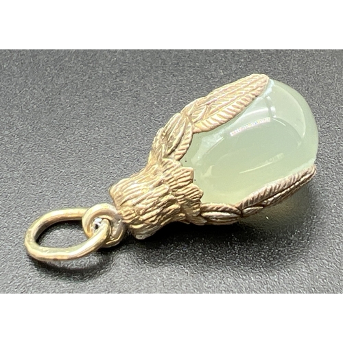 1064 - A pendant modelled as an owl with an egg shaped piece of green jade. Hanging bale tests as 9ct gold,... 