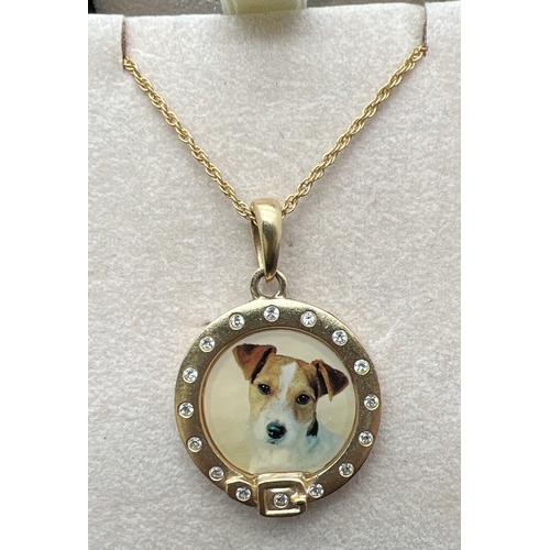 1067 - A vintage gold plated circular shaped pendant with enamelled panel featuring a Jack Russell dog. Cle... 