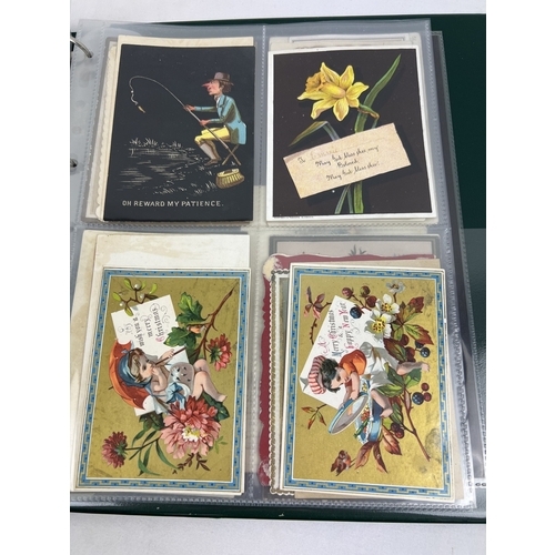 253 - An album containing 165 assorted Victorian & Edwardian greetings cards displayed in clear plastic en... 