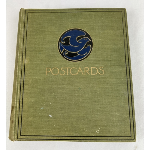 175 - An early 20th century green cloth bound postcard album with approx. 154 assorted vintage postcards r... 