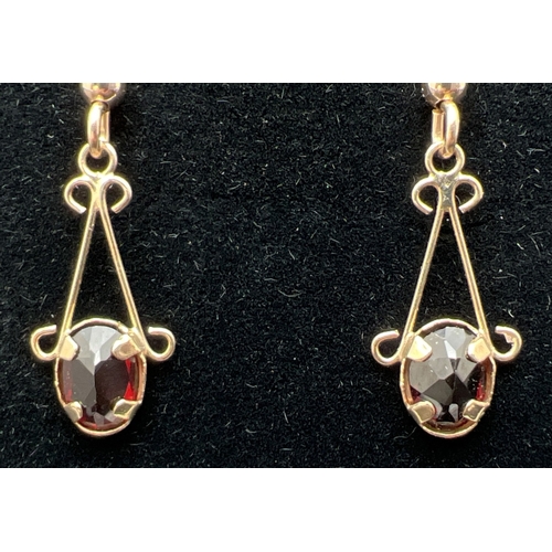 1005 - A pair of 9ct gold, garnet set drop earrings with hallmarked hooked posts. Approx. 3.5cm long. Mount... 