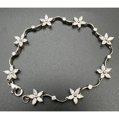 1027 - A 925 silver flower and twist link stone set bracelet. Each flower link set with 5 marquise cut clea... 