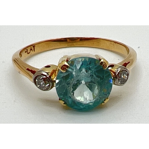 1045 - A vintage 18ct gold blue topaz and diamond dress ring. Central round cut blue topaz with a small bez... 