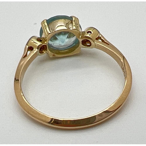 1045 - A vintage 18ct gold blue topaz and diamond dress ring. Central round cut blue topaz with a small bez... 