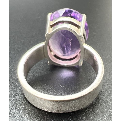 1054 - A modern design silver dress ring set with a checkerboard cut oval amethyst, stone approx. 1.75cm x ... 