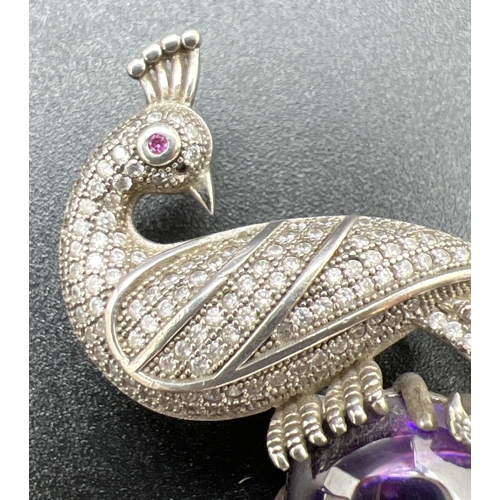 1068 - A large silver stone set pendant brooch modelled as a peacock, with large oval shaped purple cabocho... 